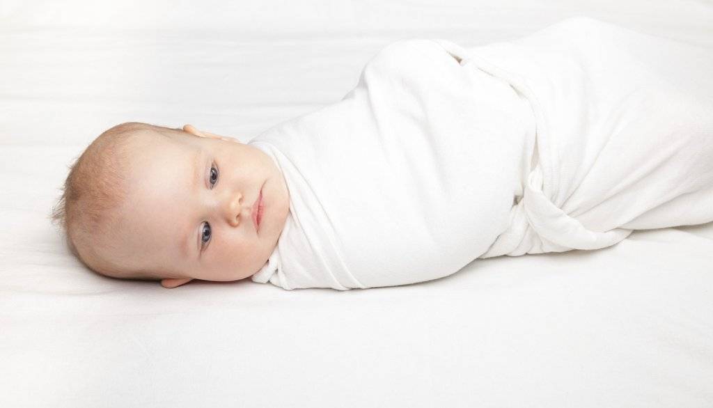 What are the benefits of swaddling a baby at night?